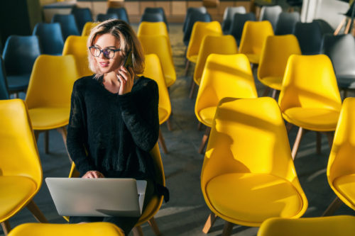 woman sitting in yellow chair with computer
